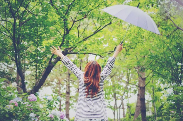 雨の日に万歳する女性